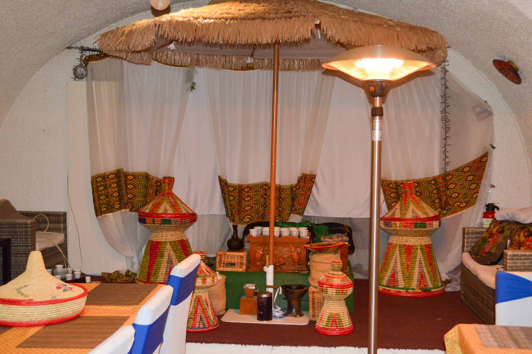 Coin traditionnel du restaurant, paniers tressés sous un parasol de paille